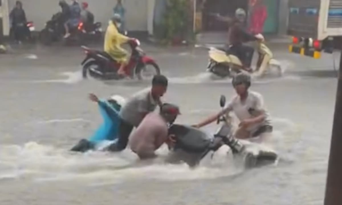 Вода течет как водопад, смывая мотоциклы